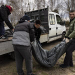 
              Cemetery workers lift three corpses of civilians killed in Bucha, to be transported to the morgue, on the outskirts of Kyiv, Ukraine, Wednesday, April 6, 2022. (AP Photo/Rodrigo Abd)
            
