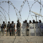 
              Security personnel stand guard during a protest in Islamabad, Pakistan, Sunday, April 3, 2022. Pakistan's embattled Prime Minister Imran Khan said Sunday he will seek early elections after sidestepping a no-confidence challenge and alleging that a conspiracy to topple his government had failed. (AP Photo/Rahmat Gul)
            