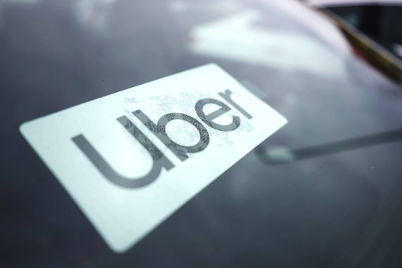 FILE - An Uber sign is displayed inside a car in Palatine, Ill., United States, Feb. 10, 2022. Uber...