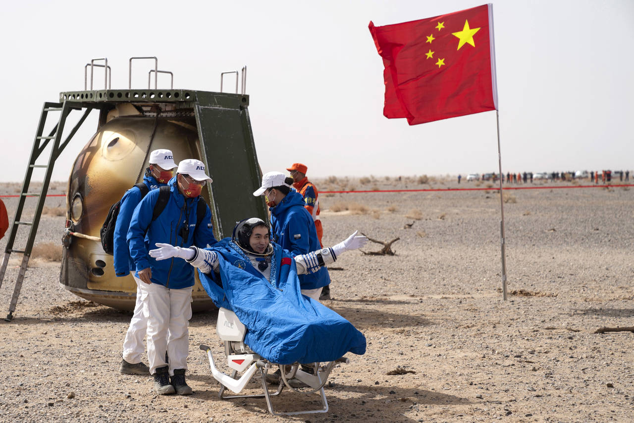 In this photo released by China's Xinhua News Agency, Chinese astronaut Ye Guangfu sits outside ret...