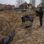 
              A journalist takes video of a mass grave in Bucha, on the outskirts of Kyiv, Ukraine, Sunday, April 3, 2022. (AP Photo/Rodrigo Abd)
            