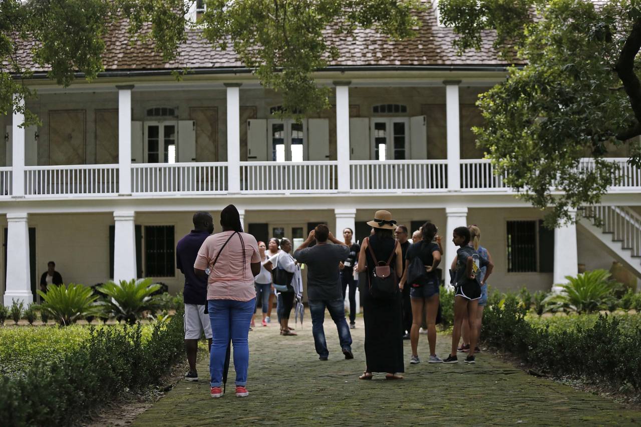 In this July 14, 2017 photo, visitors walk outside the main plantation house at the Whitney Plantat...