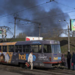 
              People board a tram, as smoke rises in the air following a Russian attack a day before, in Odesa, Ukraine, Monday, April 4, 2022. (AP Photo/Petros Giannakouris)
            