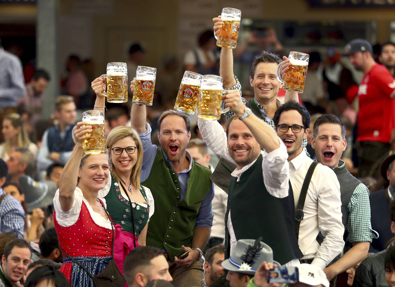 FILE - In this Saturday, Sept. 21, 2019 file photo, visitors lift glasses of beer during the openin...