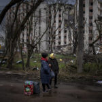 
              Women next to their belongings wait for transportation next to buildings destroyed by artillery in Chernihiv on Thursday, April 21, 2022. (AP Photo/Emilio Morenatti)
            