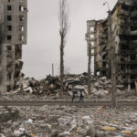 
              People walk by an apartment building destroyed during fighting between Ukrainian and Russian forces in Borodyanka, Ukraine, Tuesday, April 5, 2022. (AP Photo/Vadim Ghirda)
            