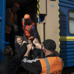 
              An elderly woman is carried on a stretcher to board a train at a train station in Pokrovsk, Ukraine, Monday, April 25, 2022, to flee the war in Severodonetsk and nearby towns. Russia unleashed a string of attacks against Ukrainian rail and fuel installations Monday, striking crucial infrastructure far from the front line of its eastern offensive. (AP Photo/Leo Correa)
            