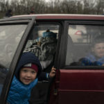 
              Rostilav, 4, left, smiles to the camera as he arrives with his family and friend Yaroslav, from Mariupol, at a refugee center fleeing from the Russian attacks, in Zaporizhzhia, Ukraine, Thursday, April 21, 2022. Mariupol, which is part of the industrial region in eastern Ukraine known as the Donbas, has been a key Russian objective since the Feb. 24 invasion began. (AP Photo/Leo Correa)
            