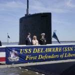 
              President Joe Biden returns a salute as he stands with first lady Jill Biden and Cmdr. Matthew Horton, Commanding Officer, USS Delaware, before they board the USS Delaware, Virginia-class fast-attack submarine, for a tour at the Port of Wilmington in Wilmington, Del., Saturday, April 2, 2022. (AP Photo/Carolyn Kaster)
            