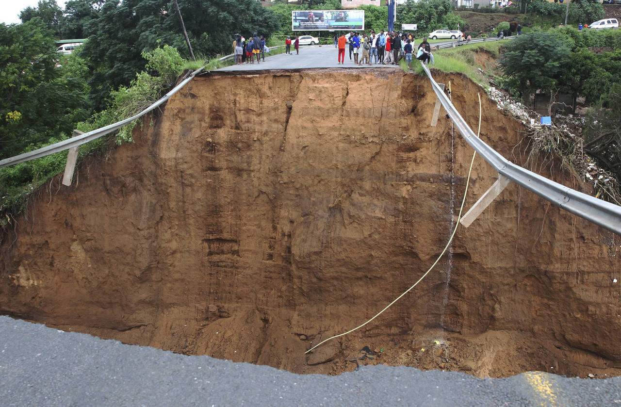 Stranded people stand in front of a bridge that was swept away in Ntuzuma, outside Durban, South Af...