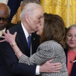 
              President Joe Biden kisses House Speaker Nancy Pelosi of Calif., during an Affordable Care Act event in the East Room of the White House in Washington, Tuesday, April 5, 2022. At left is House Majority Whip James Clyburn, D-S.C., and right is Rep. Susan Wild, D-Pa. Pelosi has tested positive for COVID-19 and is currently asymptomatic, her spokesman Drew Hammill said in a tweet Thursday, April 7. (AP Photo/Carolyn Kaster)
            