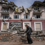 
              A man walks past an apartments building damaged by shelling in Chernihiv, Ukraine, Thursday, April 7, 2022. Ukraine is telling residents of its industrial heartland to leave while they still can after Russian forces withdrew from the shattered outskirts of Kyiv to regroup for an offensive in the country's east. (AP Photo/Evgeniy Maloletka)
            