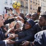 
              Centrist presidential candidate and French President Emmanuel Macron holds hands to residents during a campaign stop Thursday, April 21, 2022 in Saint-Denis, outside Paris. French voters head to polls on Sunday in a runoff vote between centrist incumbent Emmanuel Macron and nationalist rival Marine Le Pen. (Ludovic Marin, Pool via AP)
            