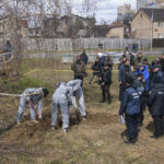 
              French forensics investigators, who arrived to Ukraine for the investigation of war crimes amid Russia's invasion, stand next to a mass grave in the town of Bucha, in Kyiv region, Ukraine, Tuesday, April 12, 2022. (AP Photo/Wladyslaw Musiienko)
            