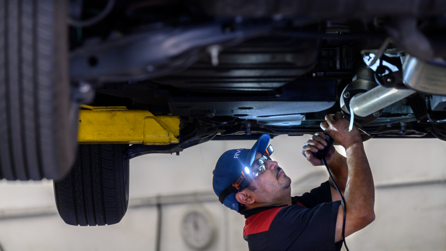 ExperTec Automotive technician Adelmo Rodriguez etches a catalytic converter with the cars license ...