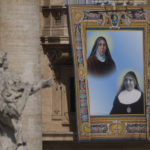 
              The tapestry depicting Maria di Gesù Santocanale (1852-1923), top, and Maria Domenica Mantovani (1862-1934) hangs in St. Peter's Square at The Vatican, Sunday, May 15, 2022, during their canonization mass celebrated by Pope Francis. Francis created ten new saints on Sunday, rallying from knee pain that has forced him to use a wheelchair to preside over the first canonization ceremony at the Vatican in over two years. (AP Photo/Gregorio Borgia)
            