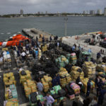 
              FILE - Journalists, politicians, and federal officials stand along with members of the U.S. Coast Guard and other law enforcement agencies, as they view more than one billion dollars worth of seized cocaine and marijuana aboard Coast Guard Cutter James at Port Everglades, Thursday, Feb. 17, 2022, in Fort Lauderdale, Fla. The Coast Guard said the haul included approximately 54,500 pounds of cocaine and 15,800 pounds of marijuana from multiple interdictions in the Caribbean Sea and the eastern Pacific. (AP Photo/Rebecca Blackwell, File)
            