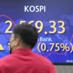 
              A currency trader walks by the screen showing the Korea Composite Stock Price Index (KOSPI) at a foreign exchange dealing room in Seoul, South Korea, Friday, May 13, 2022. Asian shares bounced back Friday from losses earlier in the week, shrugging off data showing U.S. wholesale prices soared 11% in April from a year earlier. (AP Photo/Lee Jin-man)
            