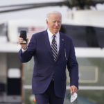 
              President Joe Biden holds a cell phone as he walks to board Air Force One at Chicago O'Hare International Airport, Wednesday, May 11, 2022, in Chicago. (AP Photo/Andrew Harnik)
            