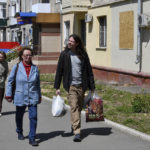 
              Patrick Michael Jones, 34, a volunteer from Houston, U.S. helps Ukrainian women Vera, 59, centre, and Lilia, 55, to carry humanitarian aid in Kramatorsk, Ukraine, Friday, May 6, 2022. Jones came to Ukraine to help people in their difficult situation. He worked as a salesman at a gun store in Houston. (AP Photo/Andriy Andriyenko)
            
