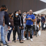 
              Migrants who had crossed the Rio Grande river into the U.S. wait to be processed by Border Patrol agents in Eagle Pass, Texas, Friday, May 20, 2022. As U.S. officials anxiously waited, many of the migrants crossing the border from Mexico on Friday were oblivious to a pending momentous court ruling on whether to maintain pandemic-related powers that deny a chance to seek asylum on grounds of preventing the spread of COVID-19. (AP Photo/Dario Lopez-Mills)
            