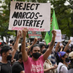 
              A protester holds a slogan during a rally in front of the office of the Commission on Elections as they question the results of the presidential elections in Manila, Philippines on Tuesday May 10, 2022. The namesake son of late Philippine dictator Ferdinand Marcos appeared to have been elected Philippine president by a landslide in an astonishing reversal of the 1986 "People Power" pro-democracy revolt that booted his father into global infamy. (AP Photo/Aaron Favila)
            