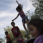 
              Eight-year-old Jeremiah Lennon, second from left, plays on a trampoline with relatives, Saturday, May 28, 2022, in Uvalde, Texas. The third grader had been in classroom 112, just next to the rooms where the shooter holed up. The kids in his class sat on the ground in the corner, as quiet as they could be, he said. The gunman tried to get in but the door was locked. Jeremiah said he was mad at first, because they were missing recess. He was also terrified: "I was scared I would get shot, my friends would get shot." (AP Photo/Wong Maye-E)
            