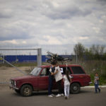 
              Orlyanske, left, hugs his wife Kolya next to their car as they arrive from Vasylivka to a reception center for displaced people in Zaporizhzhia, Ukraine, Tuesday, May 3, 2022. Thousands of Ukrainian continue to leave Russian occupied areas. (AP Photo/Francisco Seco)
            