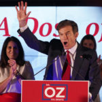 
              Mehmet Oz, a Republican candidate for U.S. Senate in Pennsylvania, right, waves in front of his wife, Lisa, while speaking at a primary night election gathering in Newtown, Pa., Tuesday, May 17, 2022. (AP Photo/Seth Wenig)
            