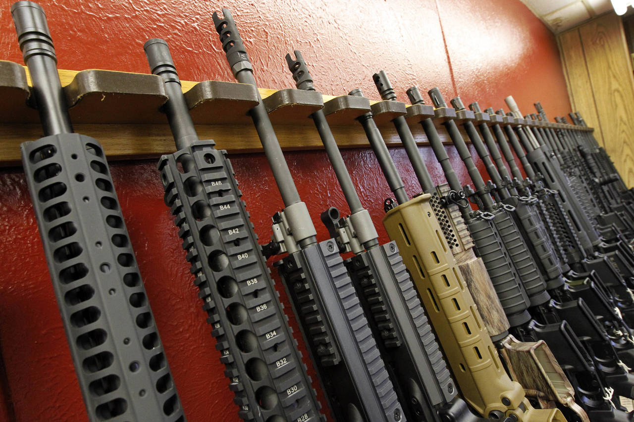 FILE - A row of rifles for sale is on display at a gun shop in Aurora, Colo., on July 20, 2012. The...