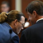 
              Actor Johnny Depp talks to his attorney Ben Chew in the courtroom at the Fairfax County Circuit Courthouse in Fairfax, Va., Tuesday, May 24, 2022. Depp sued his ex-wife Amber Heard for libel in Fairfax County Circuit Court after she wrote an op-ed piece in The Washington Post in 2018 referring to herself as a "public figure representing domestic abuse." (Jim Watson/Pool photo via AP)
            