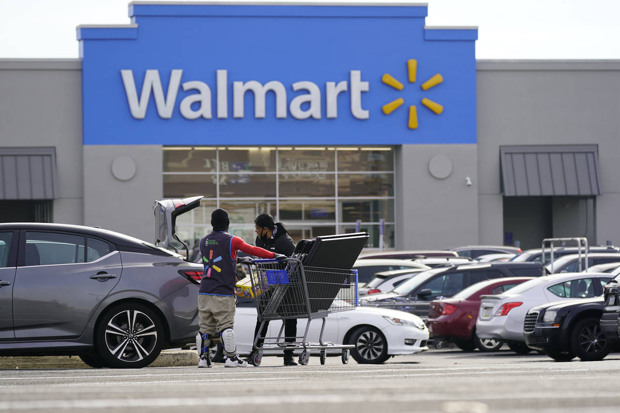 FILE - A Walmart employee helps a customer outside the Walmart store in Philadelphia, Wednesday, No...