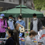 
              People wearing face masks stand in line for COVID-19 tests at a coronavirus testing site in Beijing, Wednesday, May 11, 2022. Shanghai reaffirmed China's strict "zero-COVID" approach to pandemic control Wednesday, a day after the head of the World Health Organization said that was not sustainable and urged China to change strategies. (AP Photo/Mark Schiefelbein)
            