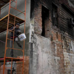 
              A man works repair a building ruined by shelling in Makariv, outskirts Kyiv, Ukraine, Friday, May 27, 2022. (AP Photo/Natacha Pisarenko)
            