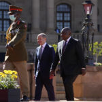 
              German Chancellor Olaf Scholz, center, walks with South Africa President Cyril Ramaphosa after the official welcoming ceremony at the Union Building in Pretoria, South Africa, Tuesday, May 24, 2022. (AP Photo/Themba Hadebe)
            