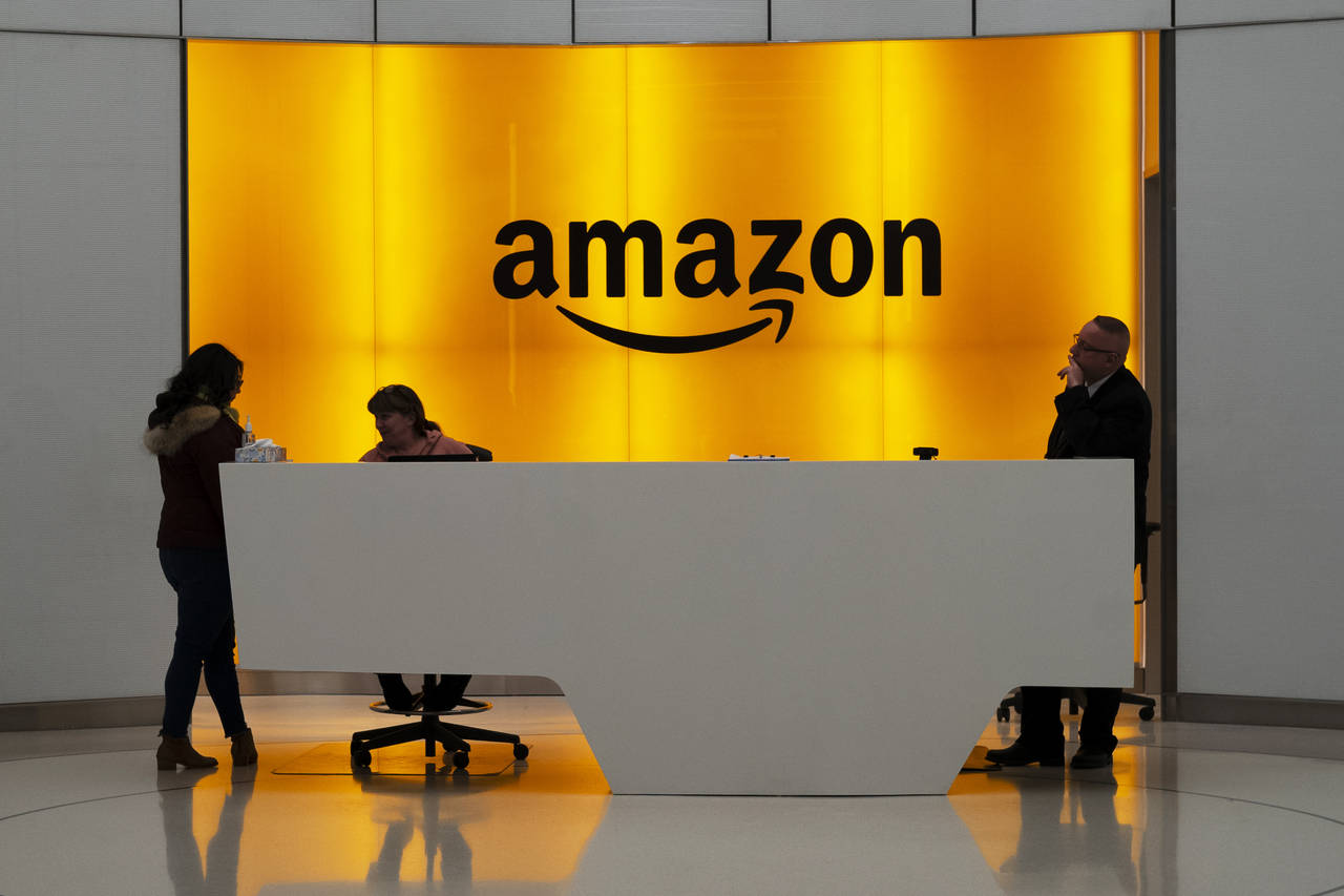 FILE - In this Feb. 14, 2019, file photo, people stand in the lobby for Amazon offices in New York....