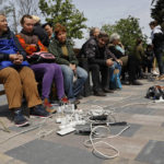 
              People charge their phones in Mariupol, in territory under the government of the Donetsk People's Republic, eastern Ukraine, Saturday, May 21, 2022. (AP Photo/Alexei Alexandrov)
            