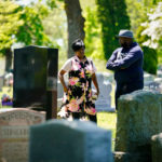 
              Latanya Byrd and Sean Williams visit the grave of Samara Banks and her three children who were struck by a car and killed in 2013 while crossing Roosevelt Boulevard, in Philadelphia, Monday, May 9, 2022. Sean Williams is the father of Saa'mir Williams, and Saa'sean Williams. (AP Photo/Matt Rourke)
            