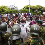 
              Sri Lankan government supporters cheer after vandalizing the site of anti-government protest outside prime minister's residence in Colombo, Sri Lanka, Monday, May 9, 2022. Authorities deployed armed troops in the capital Colombo on Monday hours after government supporters attacked protesters who have been camped outside the offices of the country's president and prime minster, as trade unions began a “Week of Protests” demanding the government change and its president to step down over the country’s worst economic crisis in memory. (AP Photo/Eranga Jayawardena)
            