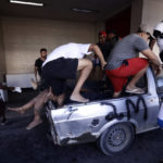 
              A pickup transporting people wounded during a police raid in the the Vila Cruzeiro favela, arrives at the Getulio Vargas Hospital in Rio de Janeiro, Brazil, Tuesday, May 24, 2022. Police raided the favela before dawn Tuesday, setting off a fierce firefight that authorities said killed more than 20 people. (AP Photo/Bruna Prado)
            