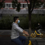 
              People wearing face masks ride along a street in Beijing, Wednesday, May 11, 2022. Shanghai reaffirmed China's strict "zero-COVID" approach to pandemic control Wednesday, a day after the head of the World Health Organization said that was not sustainable and urged China to change strategies. (AP Photo/Mark Schiefelbein)
            