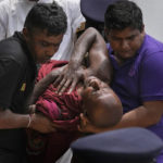 
              An injured Sri Lankan Buddhist monk is being carried away who among many other anti-government protesters were injured after attacked by government supporters outside prime minister Mahinda Rajapaksa's residence in Colombo, Sri Lanka, Monday, May 9, 2022. Government supporters on Monday attacked protesters who have been camped outside the offices of Sri Lanka's president and prime minster, as trade unions began a “Week of Protests” demanding the government change and its president to step down over the country’s worst economic crisis in memory. (AP Photo/Eranga Jayawardena)
            