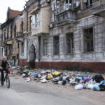 
              A woman rides a bike past a building damaged during fighting in Mariupol, in territory under the government of the Donetsk People's Republic, eastern Ukraine, Wednesday, May 25, 2022. (AP Photo)
            