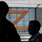 
              People walk past a letter Z, which has become a symbol of the Russian military, displayed on a building in St. Petersburg, Russia, Friday, May 6, 2022. (AP Photo/Dmitri Lovetsky)
            