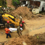 
              Firefighters carry a body recovered from a landslide triggered by heavy rain in the Jardim Monte Verde neighborhood of Recife in Pernambuco state, Brazil, Sunday, May 29, 2022. Landslides killed at least 84 people in the state of Pernambuco, according to authorities, and more than 1,000 people have been forced from their homes. (AP Photo/Joao Carlos Mazella)
            