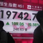 
              People wearing face masks walk past a bank's electronic board showing the Hong Kong share index in Hong Kong, Wednesday, May 11, 2022. Shares were mixed in Asia on Wednesday with Chinese benchmarks pressing higher after a rally in technology companies helped reverse most of an early slide on Wall Street. (AP Photo/Kin Cheung)
            