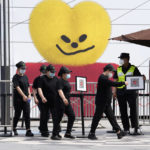 
              Workers walk out from a partial closed mall area on Monday, May 23, 2022, in Beijing. (AP Photo/Ng Han Guan)
            