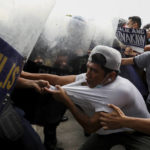 
              Police disperse activists protesting against the upcoming proclamation of presidential frontrunner Ferdinand "Bongbong" Marcos Jr. and running mate Sara Duterte, daughter of the current president, during a rally at the Commission on Human Rights in Quezon City, Metro Manila, Philippines on Wednesday May 25, 2022. Marcos Jr. continues to lead in the official canvassing of votes. (AP Photo/Basilio Sepe)
            