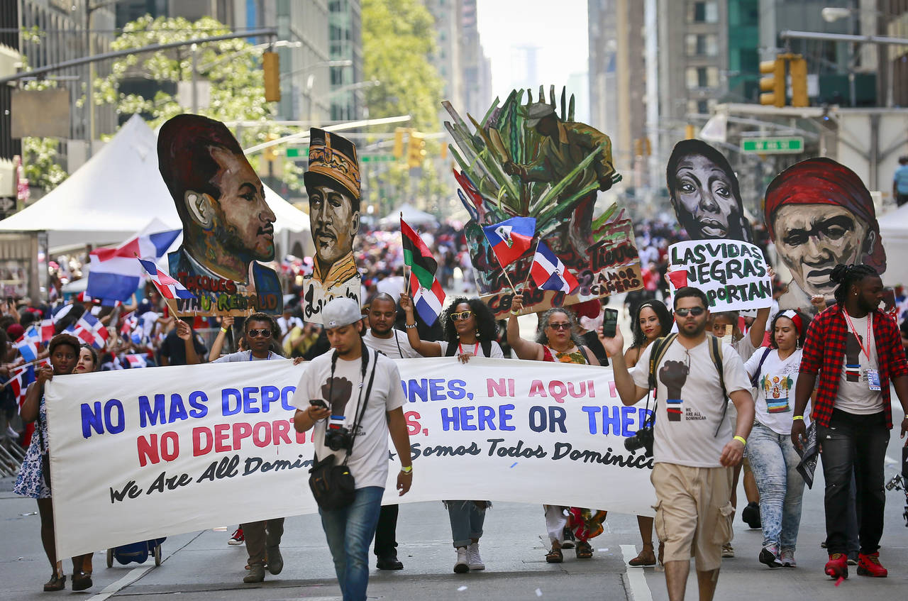 FILE - A group calling for the end of deportations marches in the Dominican Day Parade, Sunday, Aug...