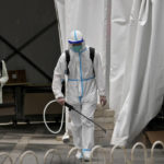 
              A worker in a protective suit sprays disinfectant at a COVID-19 testing site as a woman leaves after being tested in the Chaoyang district on Wednesday, May 11, 2022, in Beijing. Shanghai reaffirmed China's strict "zero-COVID" approach to pandemic control Wednesday, a day after the head of the World Health Organization said that was not sustainable and urged China to change strategies. (AP Photo/Andy Wong)
            